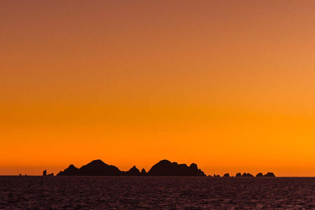Amanecer en la isla Hornos con una vista de la isla Deceit en el horizonte.